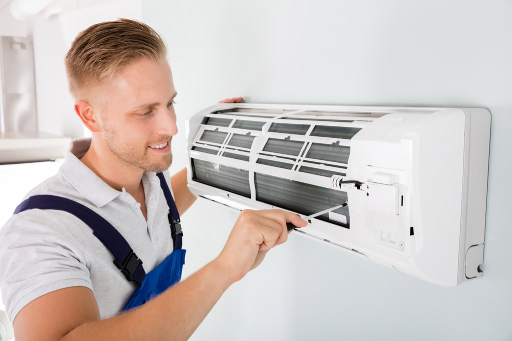 HVAC technician cleaning and repairing a ductless mini split AC in Kaysville, UT