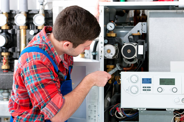 HVAC technician inspecting an indoor heating system in Kaysville, UT