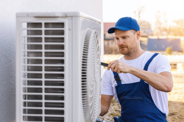 HVAC technician servicing an outdoor air conditioning unit in Kaysville